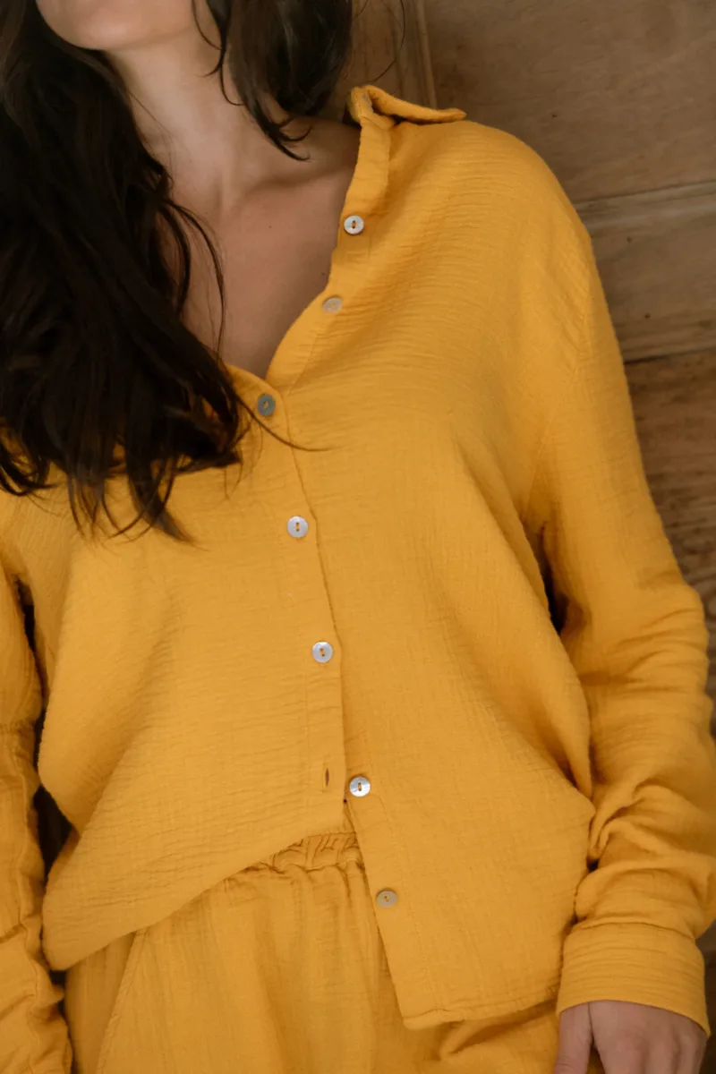 Chemise de pyjama Daphné jaune moutarde à manches longues, gros plan sur les boutons nacrés